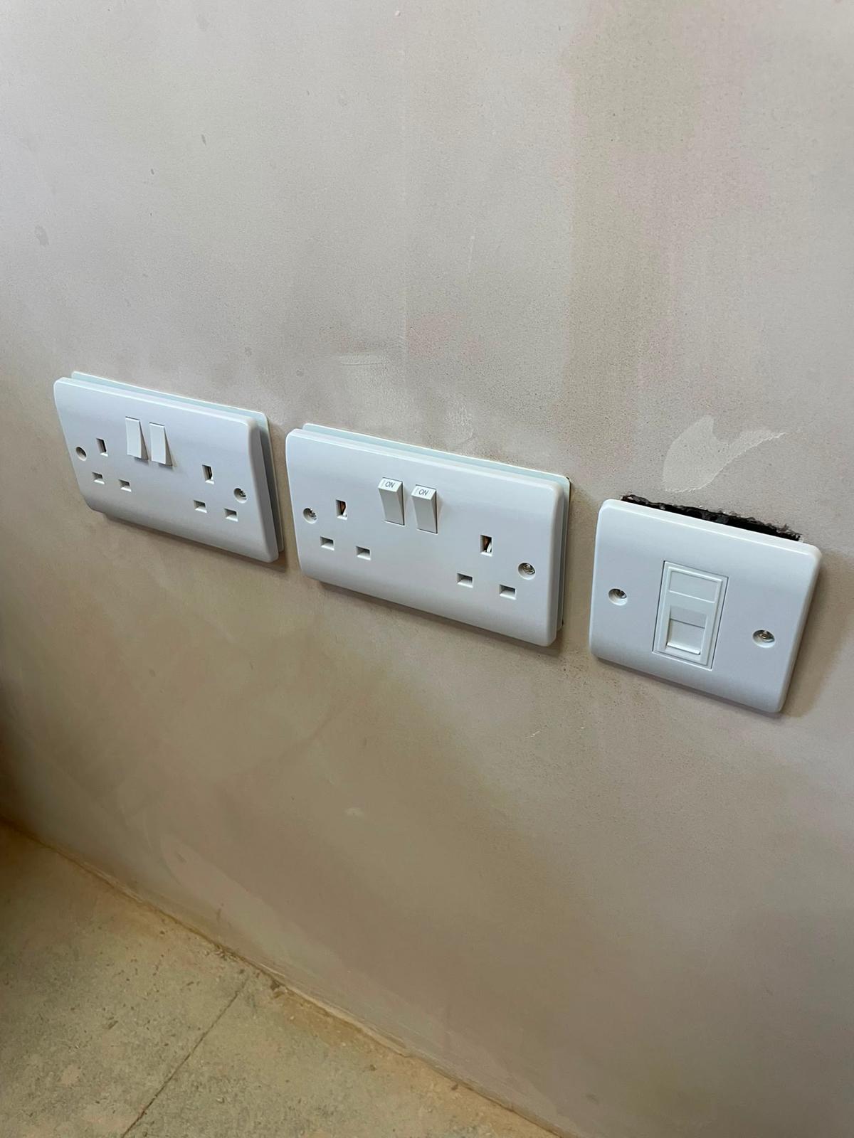 Finished double sockets and data outlet installed on a plastered wall
